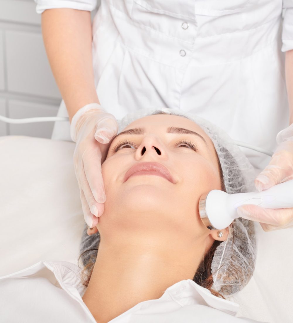 Beautician makes ultrasound skin tightening for rejuvenation woman face using phonophoresis