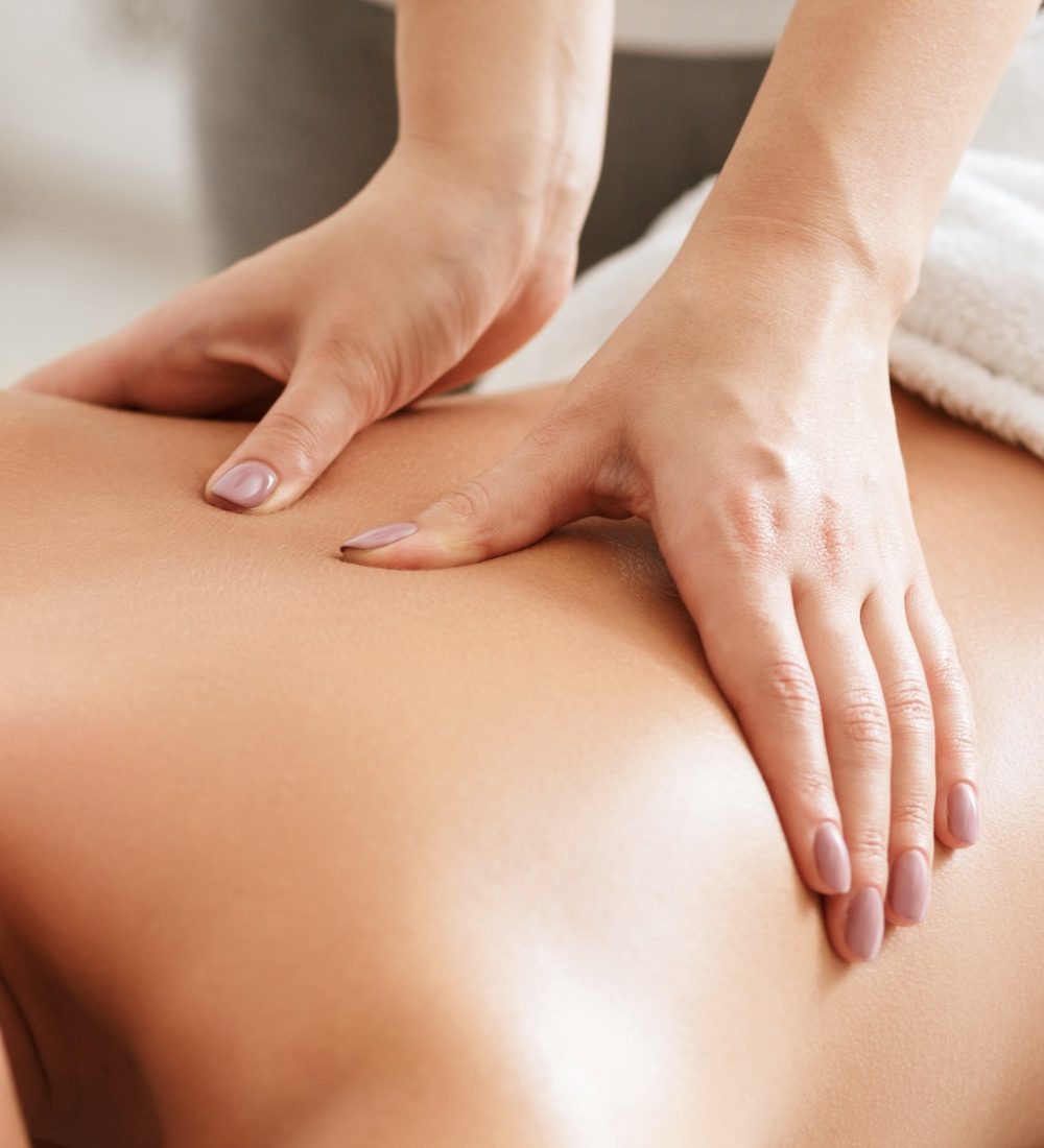 Body care. Young girl having massage, relaxing in spa salon